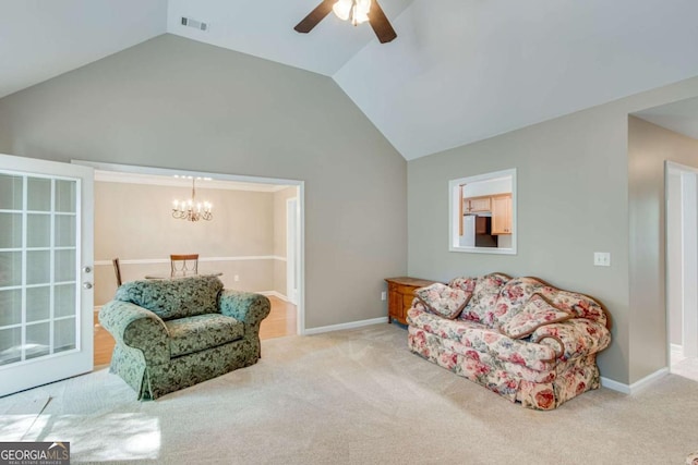 carpeted living room with ceiling fan, a chandelier, baseboards, and high vaulted ceiling