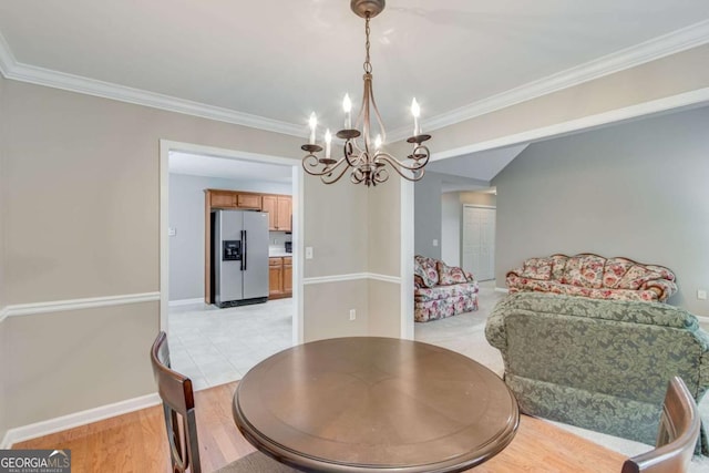 dining area featuring a chandelier, crown molding, baseboards, and light wood-style floors