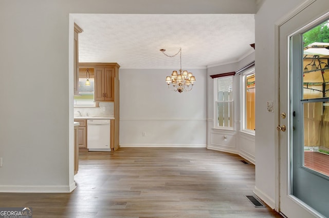 323 Newfield Way, Peachtree City, GA 30269 - unfurnished dining area with a chandelier, a textured ceiling, light wood-style flooring, baseboards, and a sink