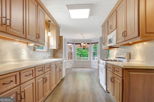 323 Newfield Way, Peachtree City, GA 30269 - kitchen with white appliances, a sink, a textured ceiling, light countertops, and decorative light fixtures