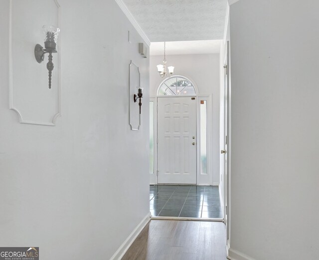 323 Newfield Way, Peachtree City, GA 30269 - doorway with a chandelier, baseboards, wood finished floors, a textured ceiling, and crown molding