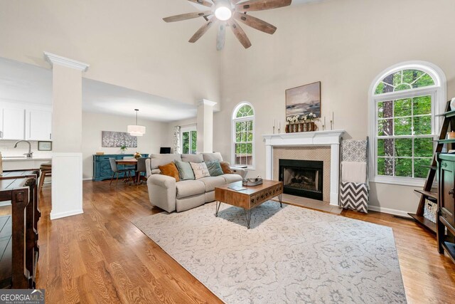 164 Stoneforest Dr, Woodstock, GA 30189 - living area with plenty of natural light, ceiling fan, light wood finished floors, and decorative columns