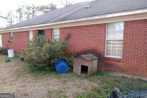906 Saint Nicholas Ave, Brewton, AL 36426 - view of property exterior featuring brick siding, a storage unit, and an outdoor structure