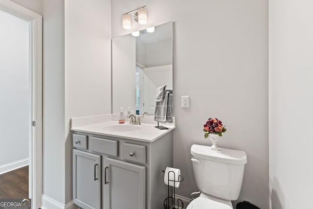 3219 Blackshear Dr, Marietta, GA 30060 - half bath featuring toilet, vanity, wood finished floors, and baseboards