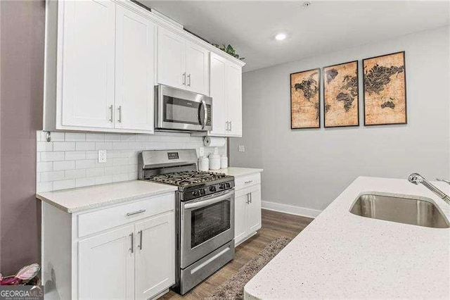 1700 Prospect Way, Conyers, GA 30094 - kitchen featuring stainless steel appliances, a sink, dark wood-style flooring, baseboards, and white cabinetry