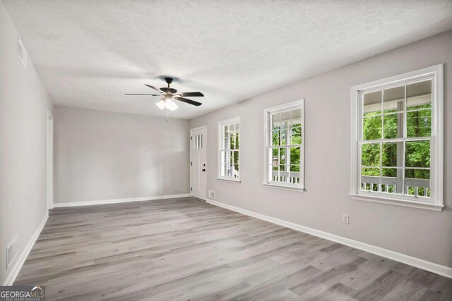 6549 Biscayne Way, Douglasville, GA 30135 - empty room featuring wood finished floors, a ceiling fan, baseboards, and a textured ceiling