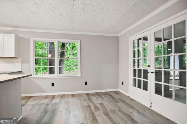 6549 Biscayne Way, Douglasville, GA 30135 - unfurnished dining area with a textured ceiling, crown molding, light wood-type flooring, french doors, and baseboards