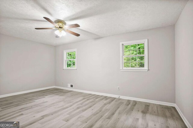 6549 Biscayne Way, Douglasville, GA 30135 - spare room with ceiling fan, light wood-style floors, a textured ceiling, and baseboards