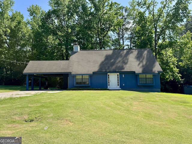 view of front of property with a carport, a front lawn, driveway, and a chimney