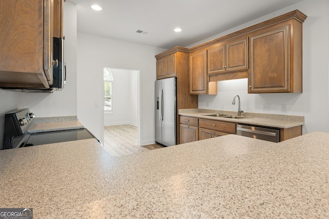 124 Cinder Hill Dr, Brunswick, GA 31523 - kitchen featuring appliances with stainless steel finishes, a sink, light countertops, brown cabinetry, and recessed lighting