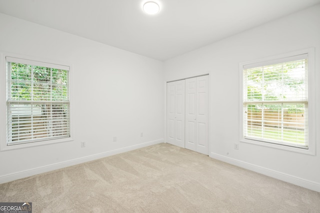 124 Cinder Hill Dr, Brunswick, GA 31523 - unfurnished bedroom featuring light carpet, multiple windows, baseboards, and a closet