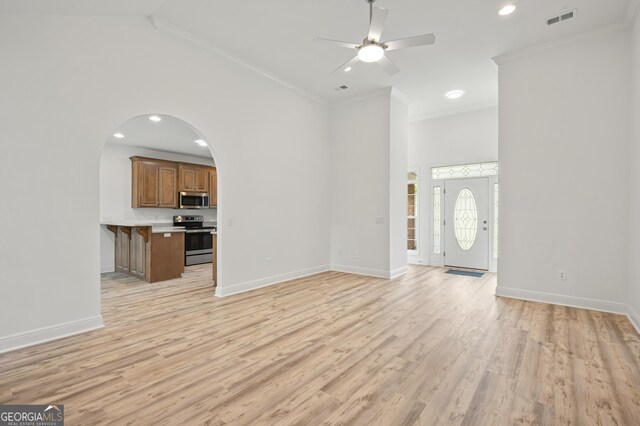 124 Cinder Hill Dr, Brunswick, GA 31523 - unfurnished living room with a towering ceiling, ornamental molding, light wood-type flooring, ceiling fan, and baseboards