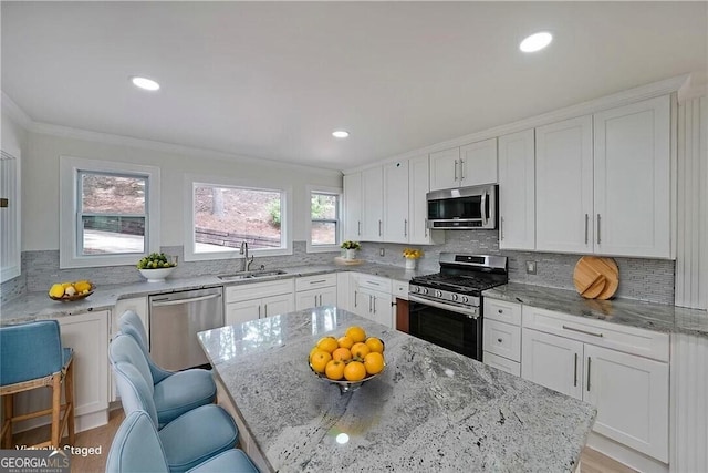 9460 Chestatee Ct, Gainesville, GA 30506 - kitchen featuring appliances with stainless steel finishes, light stone countertops, tasteful backsplash, white cabinets, and a breakfast bar area