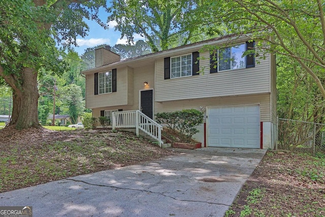5295 Old Trail Cir, Stone Mountain, GA 30088 - bi-level home with an attached garage, a chimney, and driveway