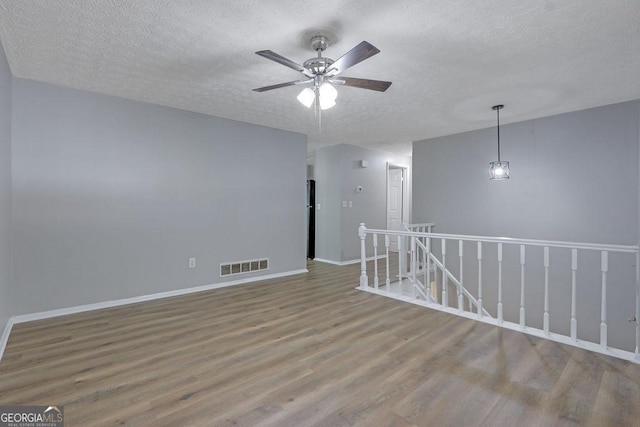 5295 Old Trail Cir, Stone Mountain, GA 30088 - empty room featuring wood finished floors, ceiling fan, and a textured ceiling