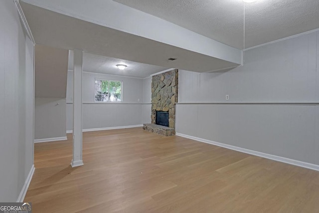 5295 Old Trail Cir, Stone Mountain, GA 30088 - below grade area with a textured ceiling, wood finished floors, and a stone fireplace