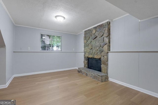 5295 Old Trail Cir, Stone Mountain, GA 30088 - unfurnished living room featuring a textured ceiling, crown molding, wood finished floors, and a stone fireplace