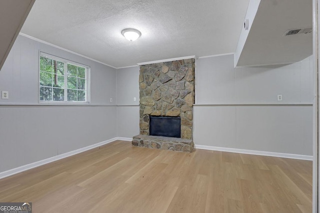 5295 Old Trail Cir, Stone Mountain, GA 30088 - unfurnished living room with ornamental molding, wood finished floors, a decorative wall, a textured ceiling, and a stone fireplace