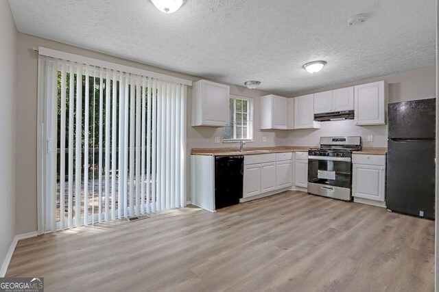 5295 Old Trail Cir, Stone Mountain, GA 30088 - kitchen featuring black appliances, light wood-style flooring, healthy amount of natural light, white cabinets, and a textured ceiling