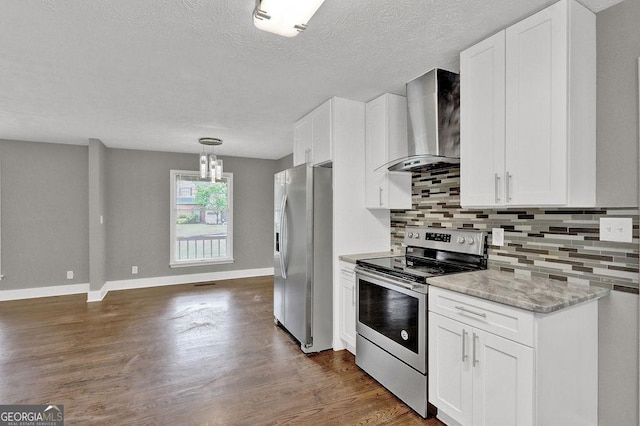 kitchen featuring appliances with stainless steel finishes, wall chimney range hood, tasteful backsplash, dark wood-type flooring, and a textured ceiling