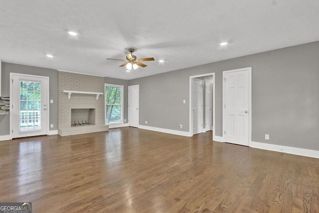 unfurnished living room featuring ceiling fan, wood finished floors, baseboards, recessed lighting, and a brick fireplace