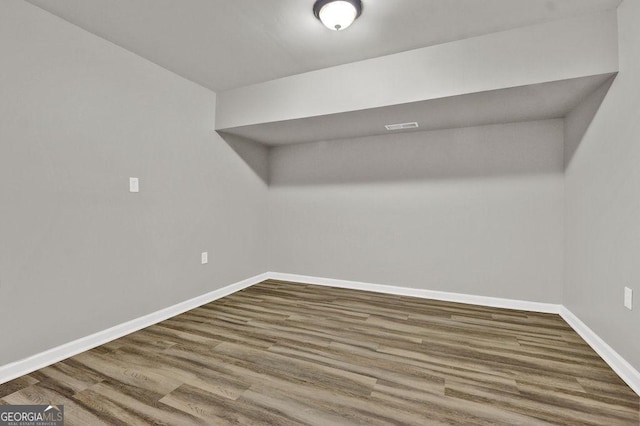 bonus room featuring baseboards and dark wood-type flooring