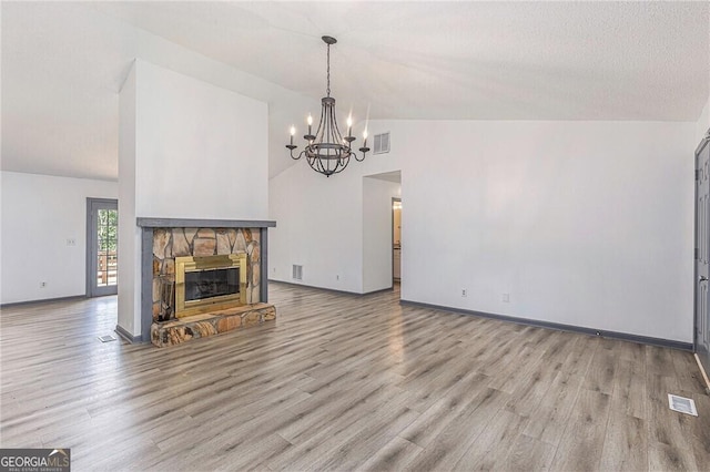 5406 Jamestowne Dr, Powder Springs, GA 30127 - unfurnished living room featuring a chandelier, wood finished floors, a fireplace, baseboards, and lofted ceiling