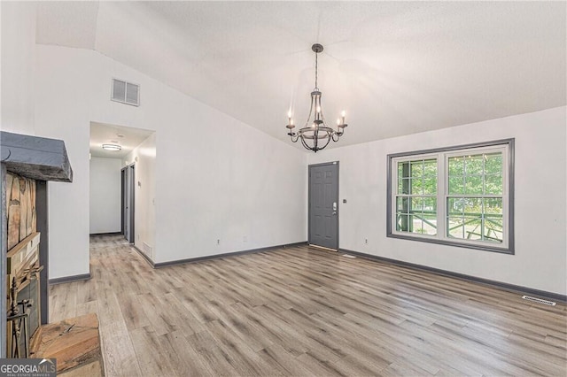 5406 Jamestowne Dr, Powder Springs, GA 30127 - unfurnished living room with vaulted ceiling, a chandelier, light wood-type flooring, and baseboards