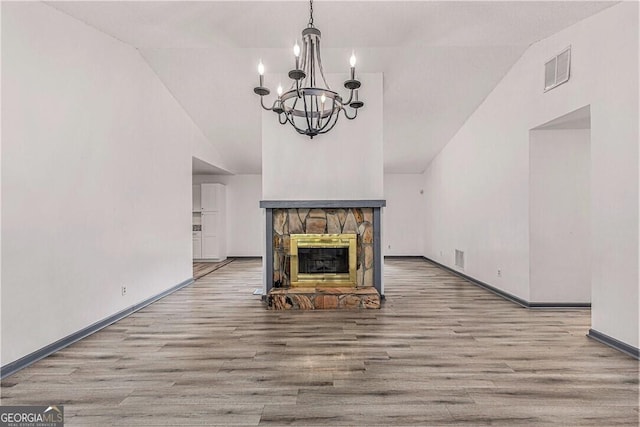 5406 Jamestowne Dr, Powder Springs, GA 30127 - unfurnished living room with wood finished floors, lofted ceiling, a chandelier, baseboards, and a fireplace