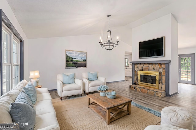 5406 Jamestowne Dr, Powder Springs, GA 30127 - living area with vaulted ceiling, a chandelier, wood finished floors, baseboards, and a stone fireplace