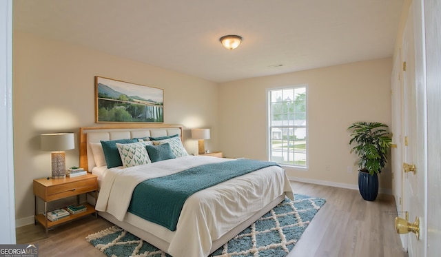 bedroom with baseboards and wood finished floors