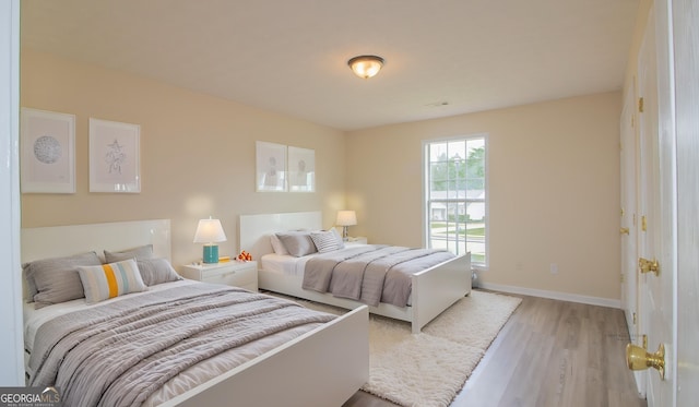 bedroom featuring light wood-type flooring and baseboards