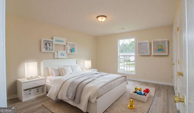 bedroom featuring light wood-style flooring and baseboards