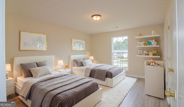 bedroom featuring light wood-style flooring and baseboards