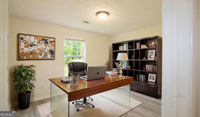 office area featuring light wood-type flooring and baseboards