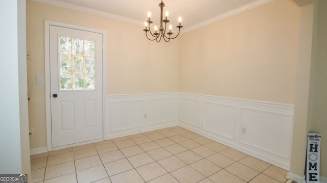 unfurnished dining area with a chandelier, crown molding, light tile patterned flooring, and wainscoting