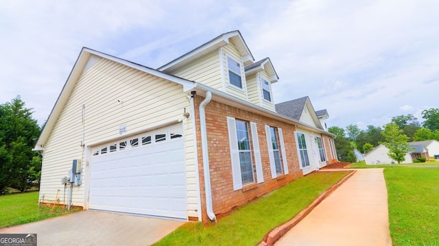 view of property exterior with brick siding, a yard, a garage, and concrete driveway