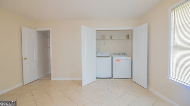 laundry room with washer and clothes dryer, light tile patterned flooring, baseboards, and plenty of natural light
