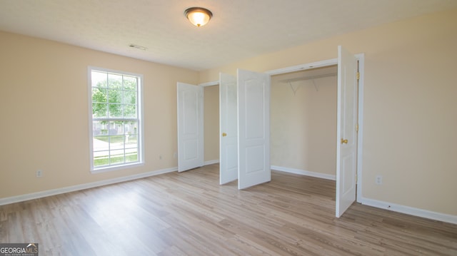 unfurnished bedroom with light wood-style flooring and baseboards
