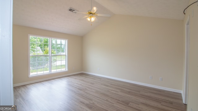 unfurnished room with wood finished floors, a ceiling fan, lofted ceiling, and baseboards