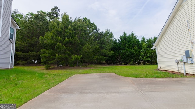 view of green lawn featuring a patio area