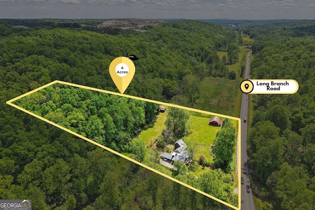 aerial view of property's location with a heavily wooded area and property parcel outlined