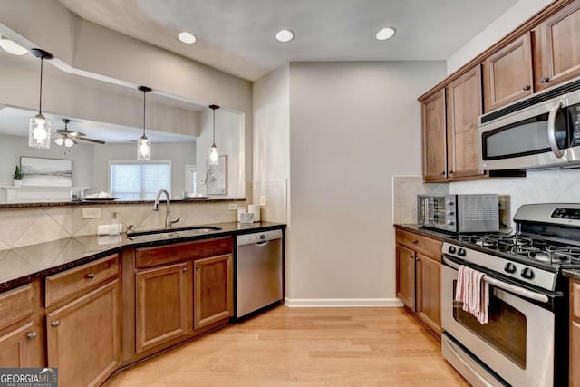 2505 Thackery Ct, Cumming, GA 30041 - kitchen featuring appliances with stainless steel finishes, a sink, tasteful backsplash, light wood finished floors, and recessed lighting