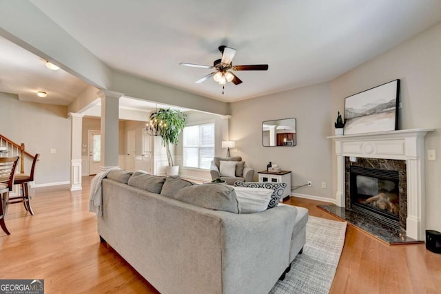 2505 Thackery Ct, Cumming, GA 30041 - living area with a ceiling fan, ornate columns, a high end fireplace, light wood-type flooring, and stairway