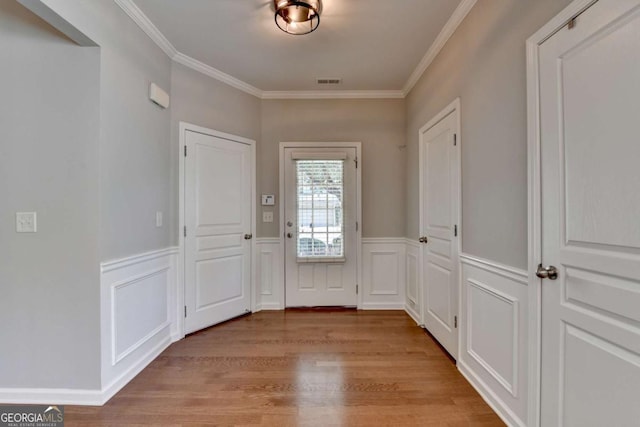 2505 Thackery Ct, Cumming, GA 30041 - entryway featuring wood finished floors, ornamental molding, a wainscoted wall, and a decorative wall