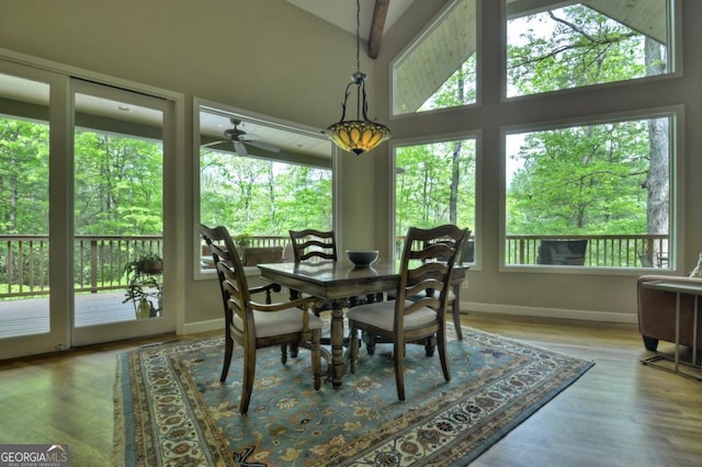 dining room featuring ceiling fan, baseboards, wood finished floors, and high vaulted ceiling