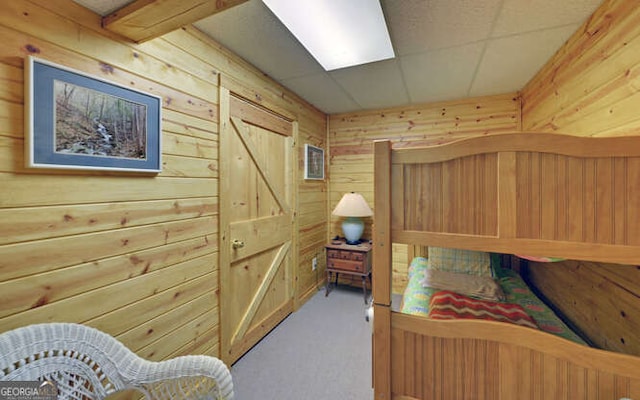 bedroom with wood walls and carpet flooring