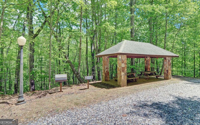 view of property's community with a gazebo and a wooded view
