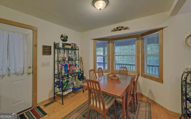 dining space featuring light wood-type flooring and baseboards