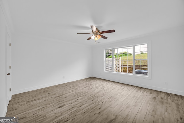 unfurnished room featuring wood finished floors, baseboards, a ceiling fan, and crown molding